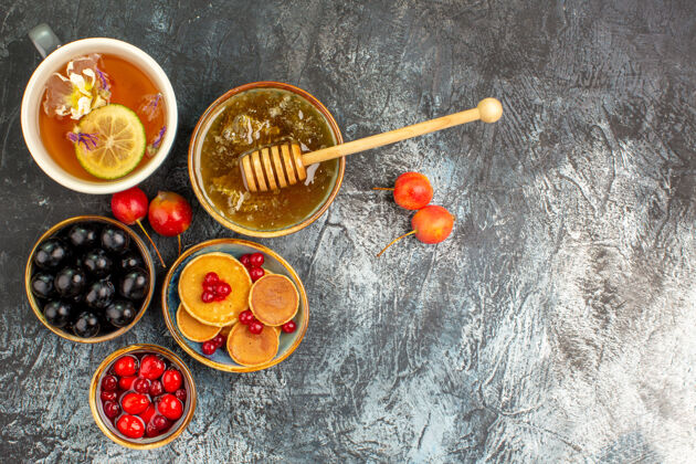 球特写镜头的经典煎饼提供蜂蜜和一杯茶杯子餐菜