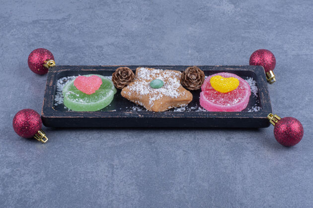 饼干一块黑木板 上面放着饼干星和甜果冻糖好吃吃圣诞球