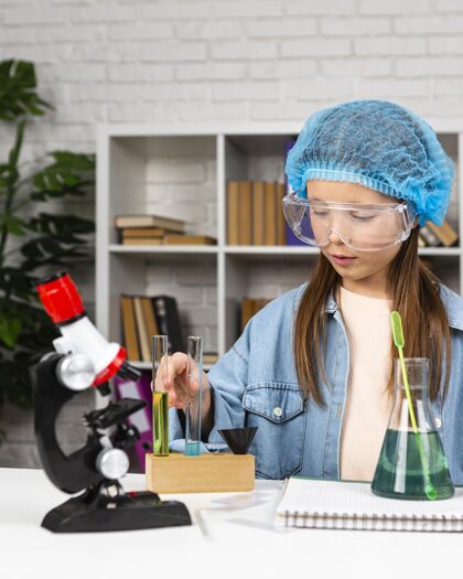 试管戴着发网的女孩用显微镜做科学实验化学网络试管