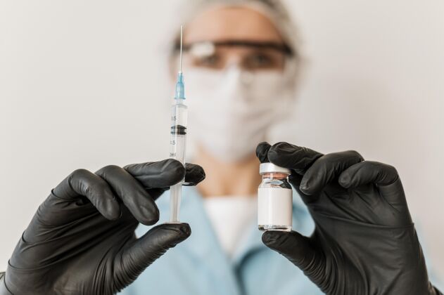 医疗戴着疫苗和手套的女医生的正面图解毒剂手套疫苗