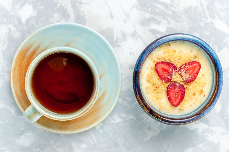 草莓俯瞰美味的奶油甜点 配上新鲜草莓和茶 背景为浅白色 甜点冰激凌 水果味甜美甜点咖啡视野