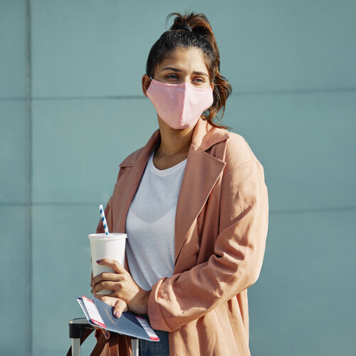 流行病大流行期间 一名妇女在机场戴着医用口罩和护照旅行女性方格