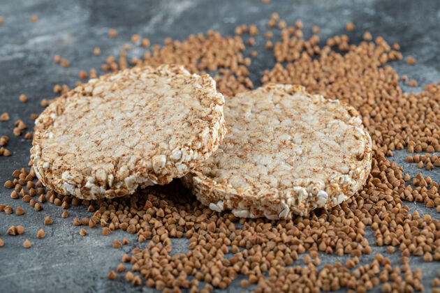 膳食的两个脆面包和生荞麦放在大理石表面零食谷物健康