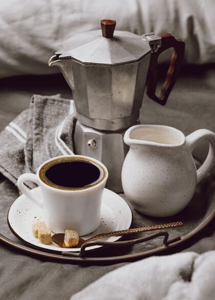 床高角度的早餐咖啡放在床上用牛奶和水壶美食垂直早午餐