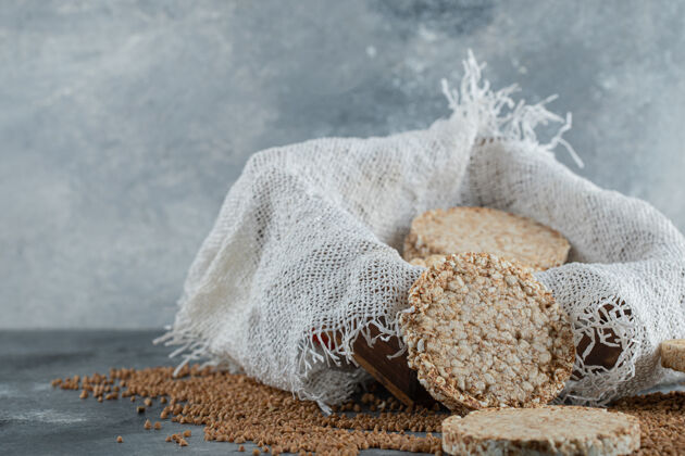 脆的美味的脆面包和生荞麦放在大理石表面脆的荞麦生的