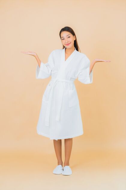 成人肖像美丽的亚洲年轻女子穿着米色的微笑浴袍健康女士看