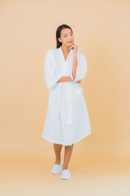 女性肖像美丽的亚洲年轻女子穿着米色的微笑浴袍面部浴室头部