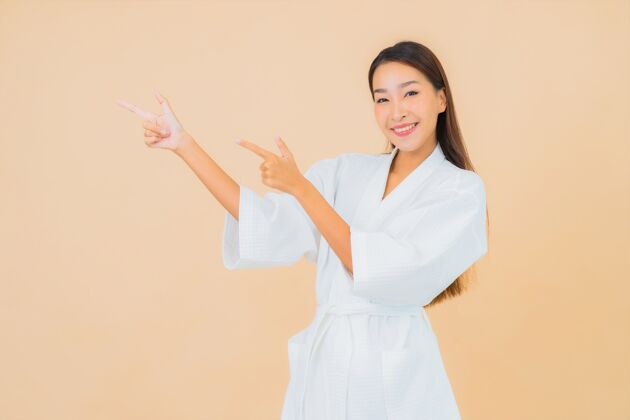 韩国肖像美丽的亚洲年轻女子穿着米色的微笑浴袍肖像浴室治疗