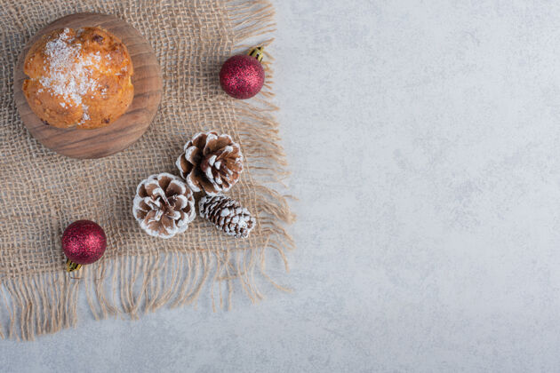 纸杯蛋糕圣诞装饰品和一块放在大理石表面的布上的纸杯蛋糕美味美味蛋卷