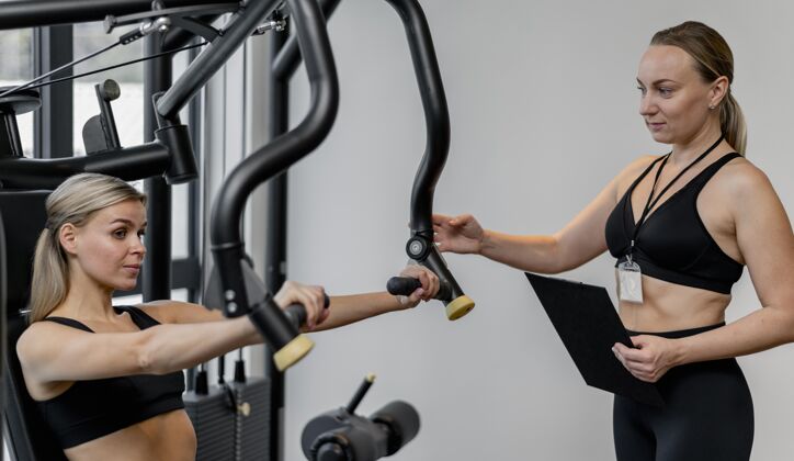健康在健身房锻炼的女人和拿着剪贴板的教练运动运动教练