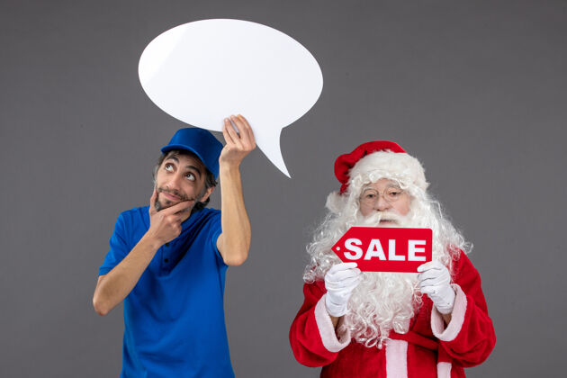 圣诞老人圣诞老人与男信使持有白色标志和灰色墙上的销售横幅前视图信使节日十二月
