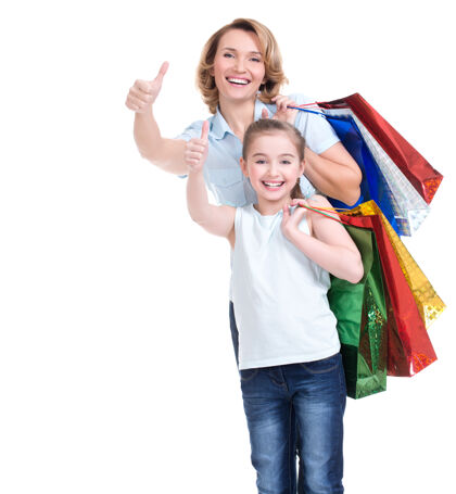 家庭快乐的白人母亲和带着购物袋的小女儿的画像竖起大拇指-孤立购物妈妈女