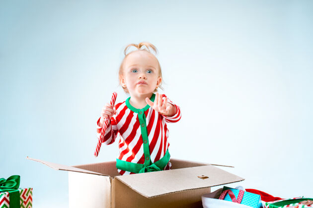 圣诞老人可爱的女婴1岁坐在盒子里过圣诞节球可爱惊讶