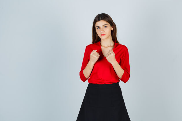 空间穿着红衬衫 黑裙子的年轻女士握紧拳头 看上去很自信自信电脑漂亮