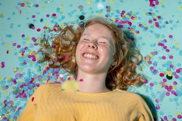 女人笑脸女人躺在地板上 周围有五彩纸屑生日五彩纸屑乐趣