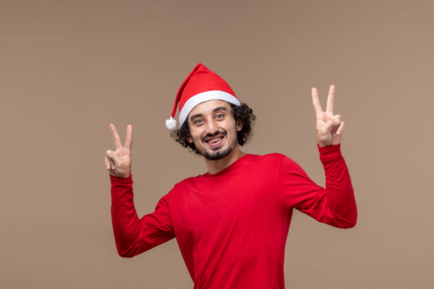 成人正面图：棕色背景上的红衣笑脸男士圣诞节圣诞节男性微笑