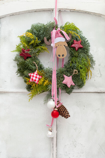 冬天垂直拍摄的装饰圣诞花环与装饰挂在白色的门房子松装饰