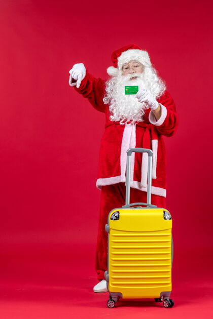 人们红墙上挂着黄色袋子 手里拿着绿色银行卡的圣诞老人的正视图十二月圣诞圣诞快乐