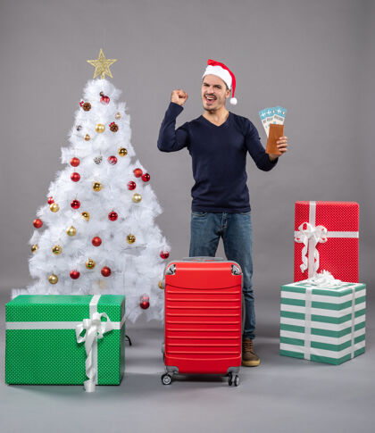 圣诞老人拿着手提箱的人高兴地拿着灰色的旅行票礼物高兴的男人礼物