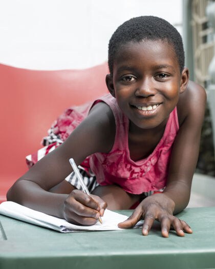 世界中镜头笑脸女孩写在笔记本上种族孩子文化
