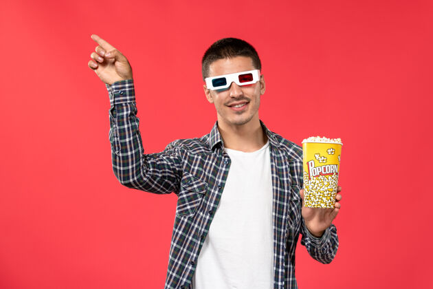 电影红墙电影院 年轻男子戴着太阳镜拿着爆米花爆米花年轻吉他