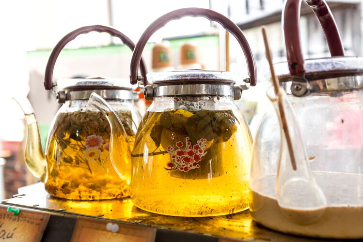 香气特写镜头三个玻璃壶与新鲜绿茶新鲜刷新壶
