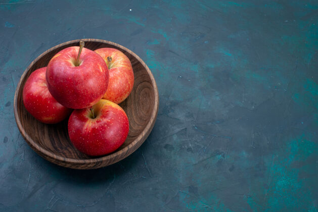 醇香前视图新鲜的红苹果醇厚和新鲜的水果在深蓝色的桌子上水果新鲜醇厚成熟的树饮食水果办公桌