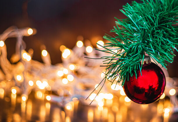 球一个红色圣诞球在松树上的选择性聚焦拍摄 背景上有灯光圣诞树背景新的