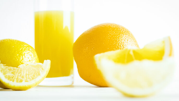 光明玻璃橙汁和白色木桌上的装饰片木材自然素食