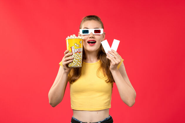 电影院正面图年轻女性在电影院拿着爆米花和票戴着d太阳镜上红墙电影院女彩剧院年轻女性年轻人