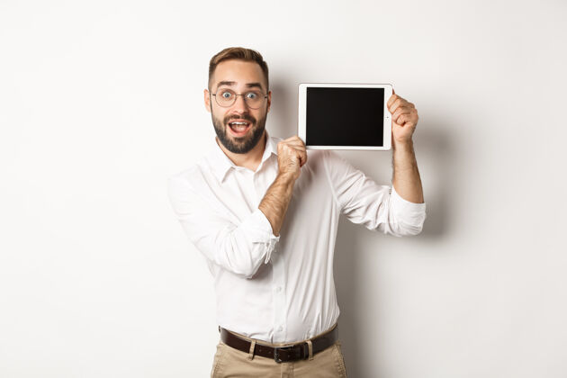 应用程序购物与科技帅哥展示数码平板电脑屏幕 戴眼镜搭配白领衬衫 工作室背景胡须雇主商人