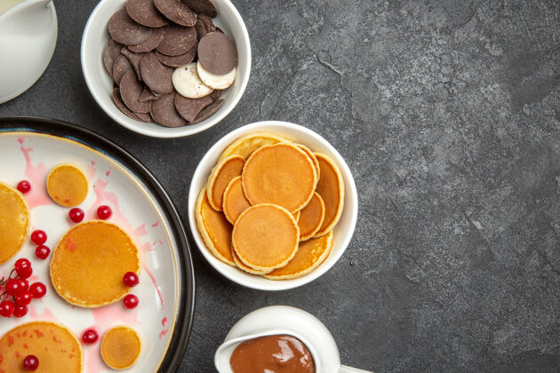 盘子在灰色背景上俯瞰美味的薄饼和饼干早餐视野曲奇
