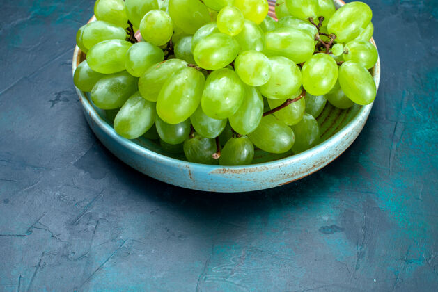 蓝色半顶视图新鲜的绿色葡萄醇厚和多汁的水果在深蓝色桌板内水果绿色葡萄