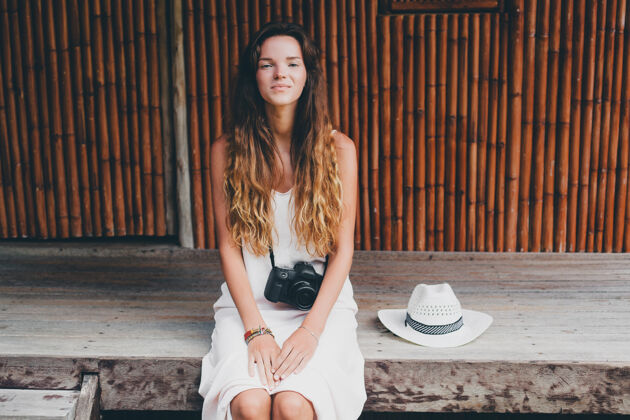 肖像亚洲热带度假的年轻美女 夏季风格 白色波西米亚裙 运动鞋 数码相机 旅行者 草帽 微笑 波西米亚年轻魅力夏天