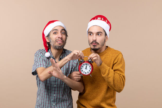 时钟前视图两个男人都拿着红色的时钟在孤立的背景上前面视图两个