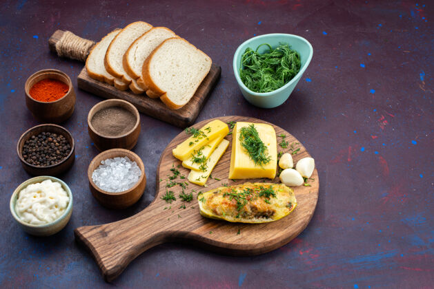 菜肴半俯视图 深紫色桌上放着美味的南瓜 调味料 绿色奶酪和面包绿色南瓜深色