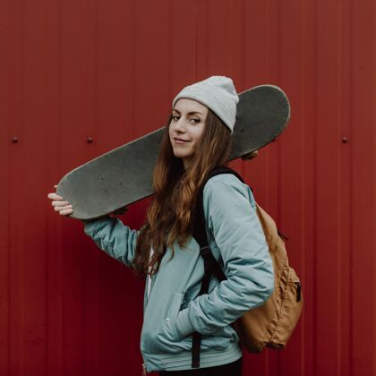 户外滑板女孩和她的滑板在城市里滑板女人女性
