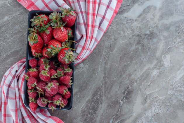盘子多汁的浆果拼盘 大理石上有草莓和覆盆子顶部覆盆子水果