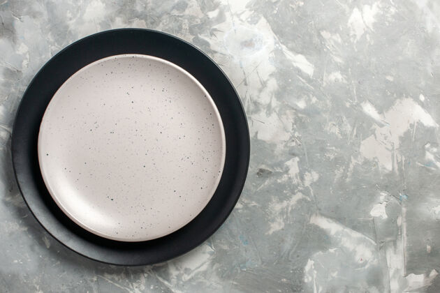 厨房黑色圆形空板顶视图 灰色表面上有白色板空的有色的餐具