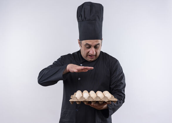 中年惊讶的中年男厨师身着厨师制服手持一批鸡蛋举起手来鸡蛋厨师批