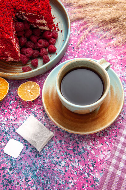 饼干半顶视图红色覆盆子蛋糕和一杯茶放在粉红色的桌子上糖饮料食品