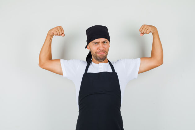 糕点面包师身穿t恤 围裙 展示手臂肌肉 看上去很有力量面包师面包年轻