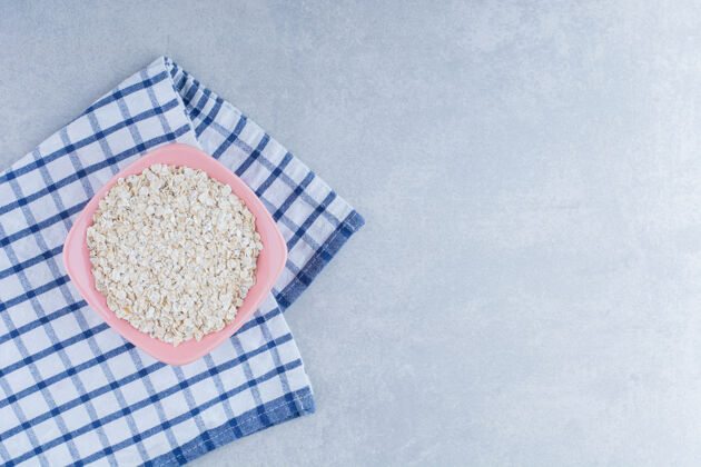 拼盘折叠桌布下面的一碗燕麦片大理石背景粮食桌布燕麦