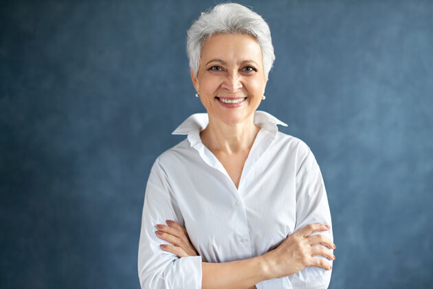 自信穿着白色正式衬衫的时尚中年女活动经理的肖像 双臂交叉放在胸前人女士时尚
