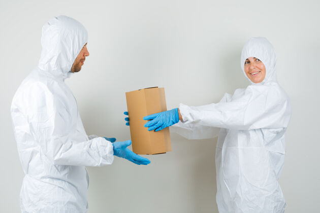 健康两个医生穿着防护服互相送纸板箱专家医学现代
