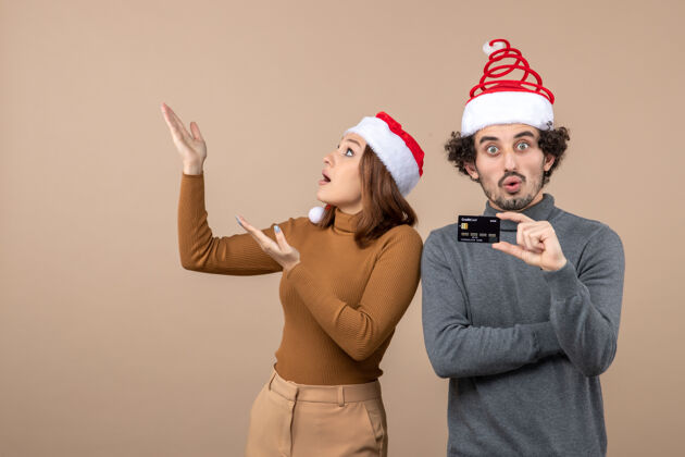 心情圣诞节心情激动满意震惊酷酷情侣戴红色圣诞老人帽出示银行卡酷情侣圣诞老人酷