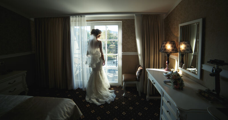 婚姻新娘从酒店房间透过窗户看肖像新娘已婚
