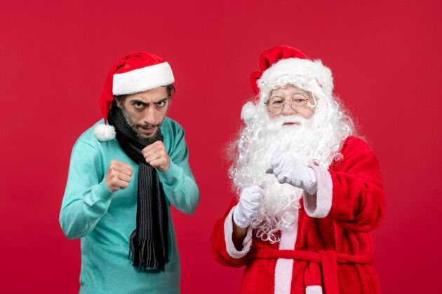 圣诞老人正面图：圣诞老人和年轻的男性站在一起年轻男人圣诞
