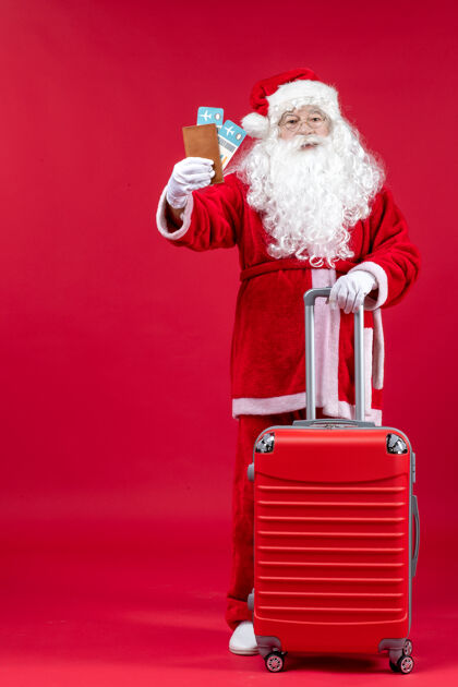 假期前视图的圣诞老人与包举行门票和准备旅行的红墙旅行快乐前面
