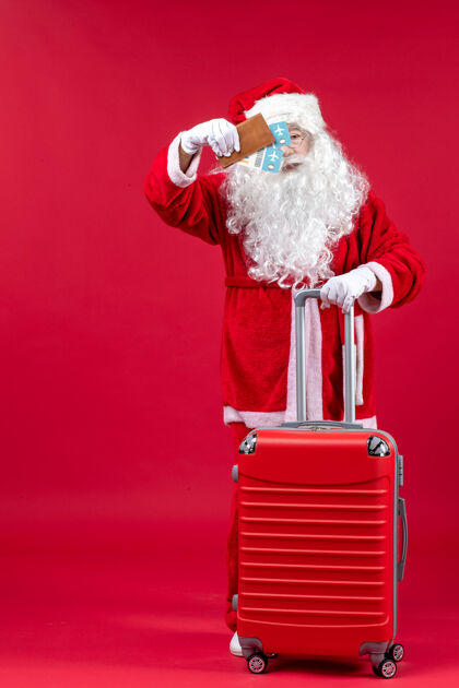 快乐圣诞老人背着包拿着票 正准备在红墙上旅行票前面成人